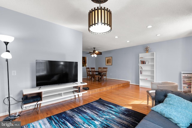 living area with baseboards, a ceiling fan, wine cooler, and wood finished floors