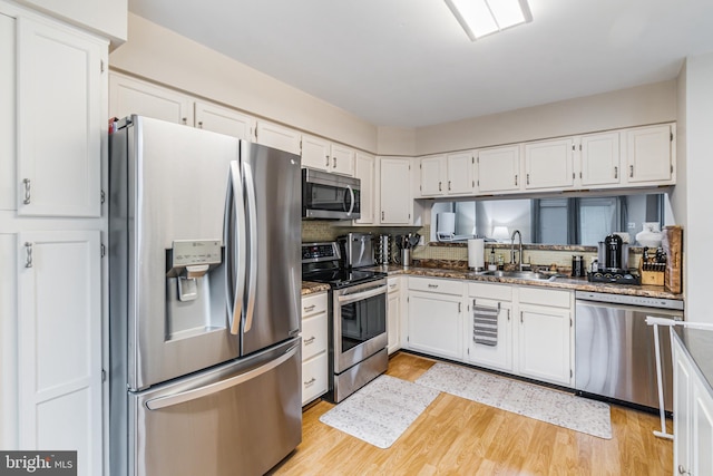 602 Lions Gate Ln, Odenton, MD 21113 - kitchen with white cabinetry, light wood finished floors, stainless steel appliances, and a sink