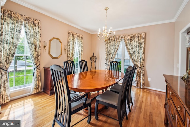 dining area featuring baseboards, an inviting chandelier, ornamental molding, and light wood-style floors