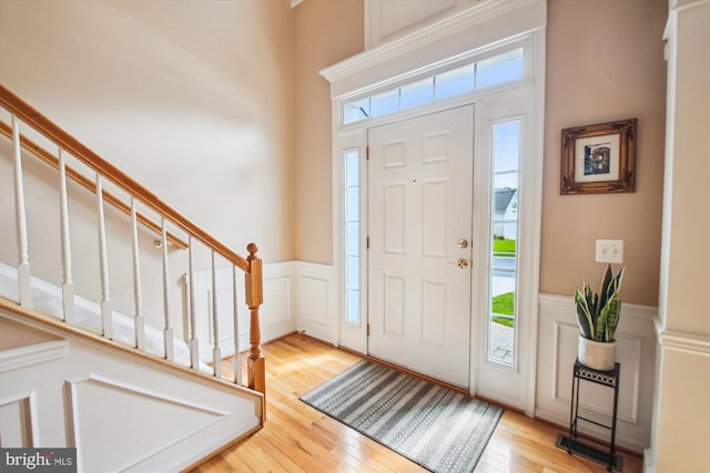 foyer entrance featuring a wainscoted wall, a wealth of natural light, and a decorative wall