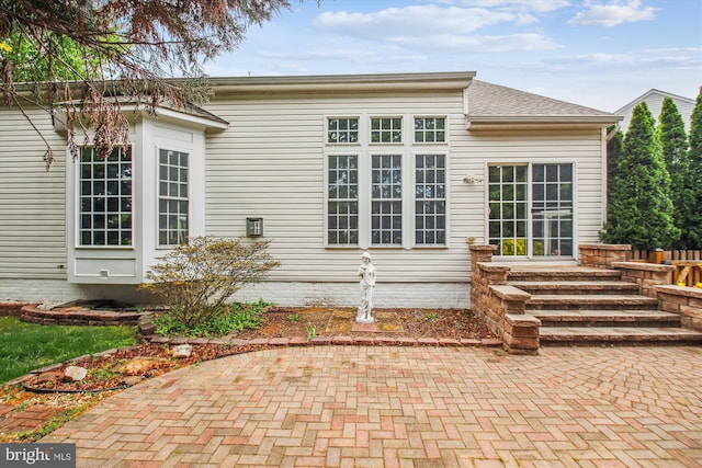 back of house featuring a shingled roof and a patio area
