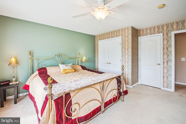 bedroom featuring carpet floors, baseboards, wallpapered walls, and a closet