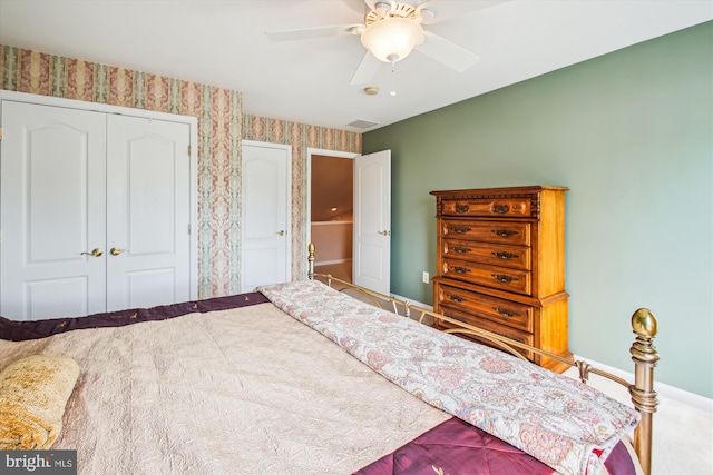 bedroom with a ceiling fan, carpet floors, baseboards, a closet, and wallpapered walls
