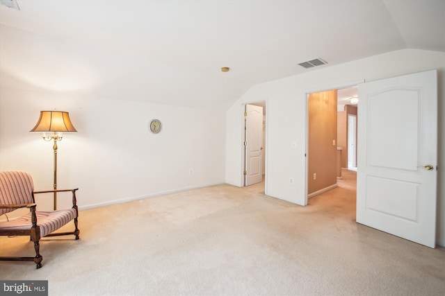 unfurnished room with baseboards, vaulted ceiling, light carpet, and visible vents