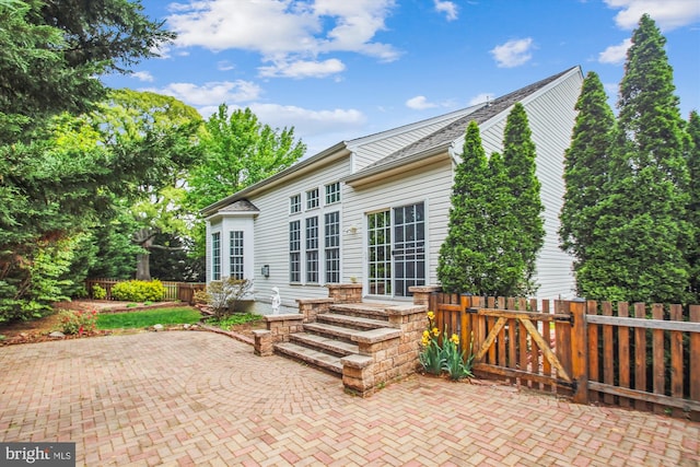 rear view of house with a patio and fence