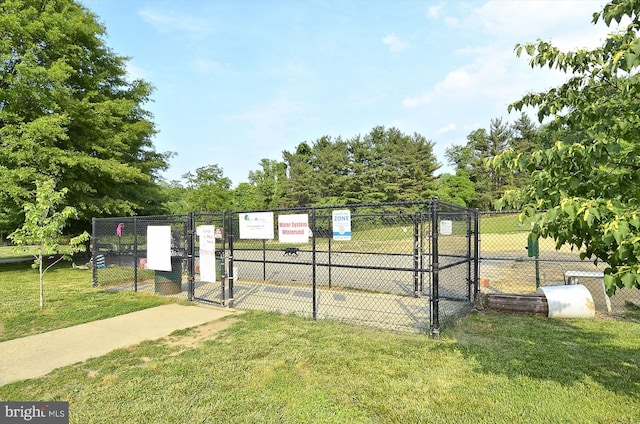surrounding community featuring a lawn, fence, and a gate