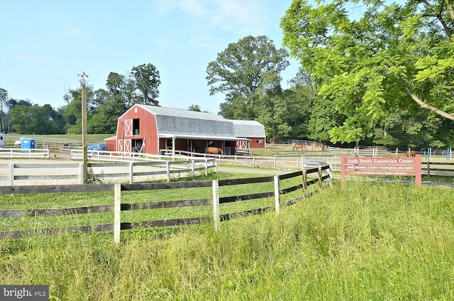 view of yard with a barn, an exterior structure, an outbuilding, and a rural view