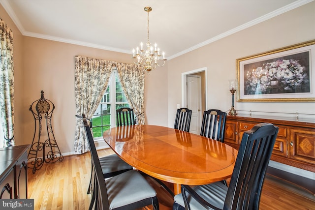 dining space with a chandelier, ornamental molding, and light wood finished floors