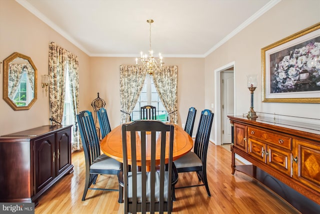 dining space with light wood-style floors, ornamental molding, and a chandelier