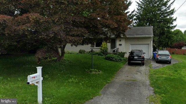 obstructed view of property featuring a garage, a front lawn, fence, and driveway