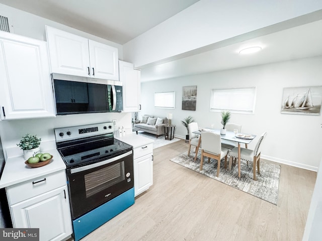 21 Onaway Pl, New Castle, DE 19720 - kitchen with range with electric stovetop, light wood-type flooring, light countertops, stainless steel microwave, and white cabinetry