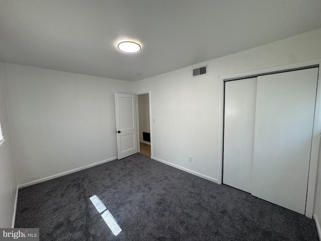 21 Onaway Pl, New Castle, DE 19720 - unfurnished bedroom with baseboards, visible vents, dark carpet, and a closet
