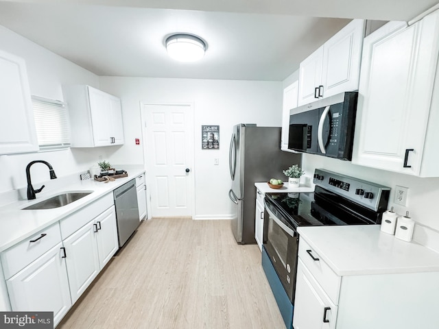 21 Onaway Pl, New Castle, DE 19720 - kitchen featuring appliances with stainless steel finishes, light wood-type flooring, a sink, light countertops, and white cabinets