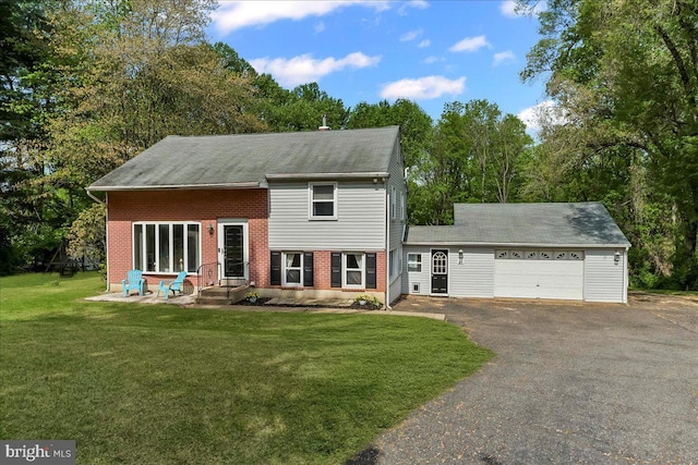 colonial home with a front yard, brick siding, aphalt driveway, an attached garage, and entry steps
