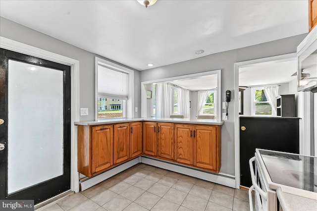 kitchen featuring white electric range, brown cabinets, light countertops, light tile patterned floors, and a baseboard radiator
