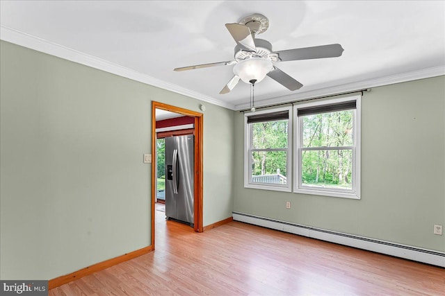 unfurnished room featuring baseboards, ornamental molding, baseboard heating, and light wood-style flooring