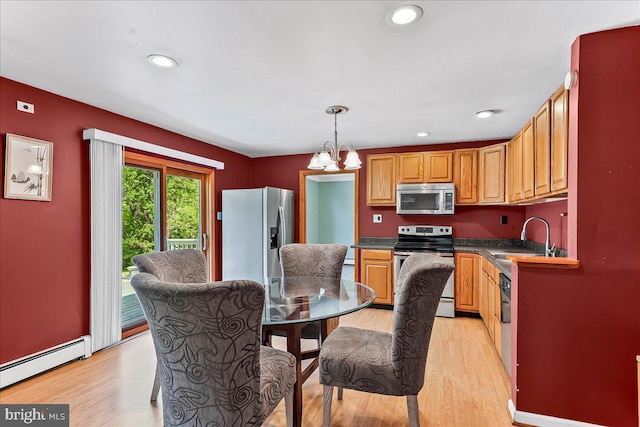 kitchen featuring appliances with stainless steel finishes, light wood-type flooring, a sink, and a baseboard radiator