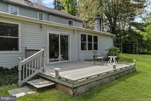 rear view of house featuring a lawn, a deck, and a chimney