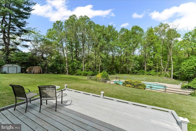 wooden deck with an outdoor structure, a shed, and a yard