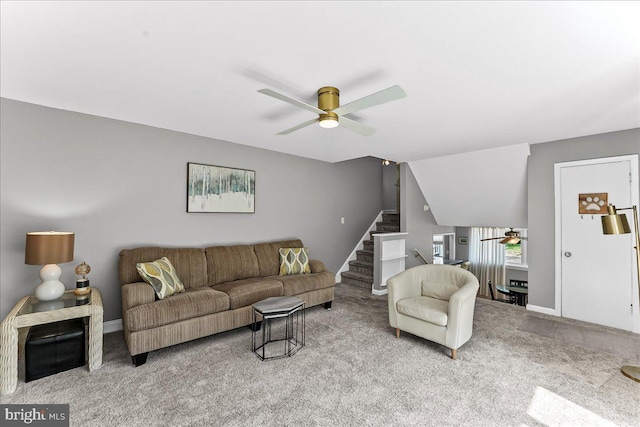 living room featuring carpet floors, a ceiling fan, baseboards, and stairway