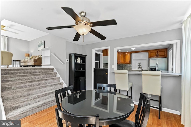 dining room with light wood-style floors and a ceiling fan