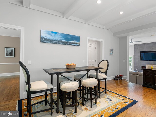 dining room featuring baseboards, recessed lighting, beamed ceiling, and wood finished floors