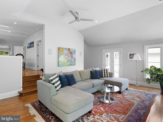 living room with a ceiling fan, vaulted ceiling, and a healthy amount of sunlight