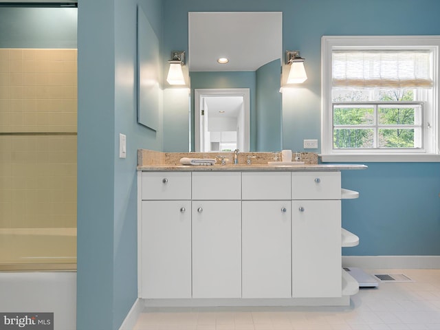 bathroom with baseboards, visible vents, a tub to relax in, and vanity