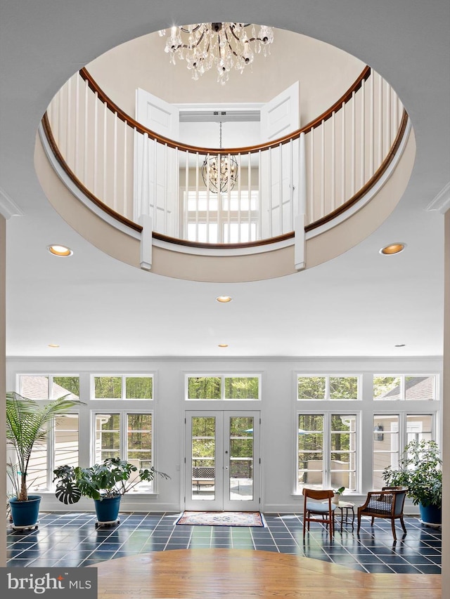 interior space featuring recessed lighting, a towering ceiling, a chandelier, and french doors