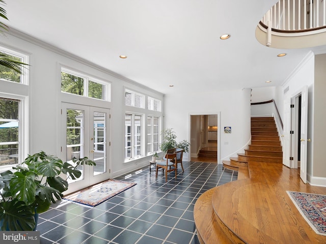 foyer entrance featuring ornamental molding, french doors, stairs, and a wealth of natural light