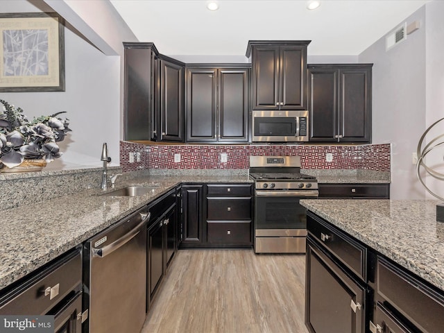 2004 Quandary Dr, Frederick, MD 21702 - kitchen featuring appliances with stainless steel finishes, light stone counters, a sink, light wood-style floors, and visible vents
