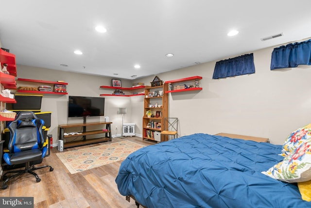 bedroom featuring baseboards, recessed lighting, wood finished floors, and visible vents