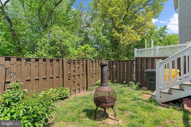 view of yard with a fire pit and fence
