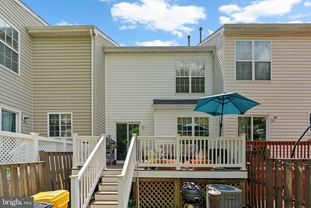 rear view of house featuring central AC unit and a wooden deck
