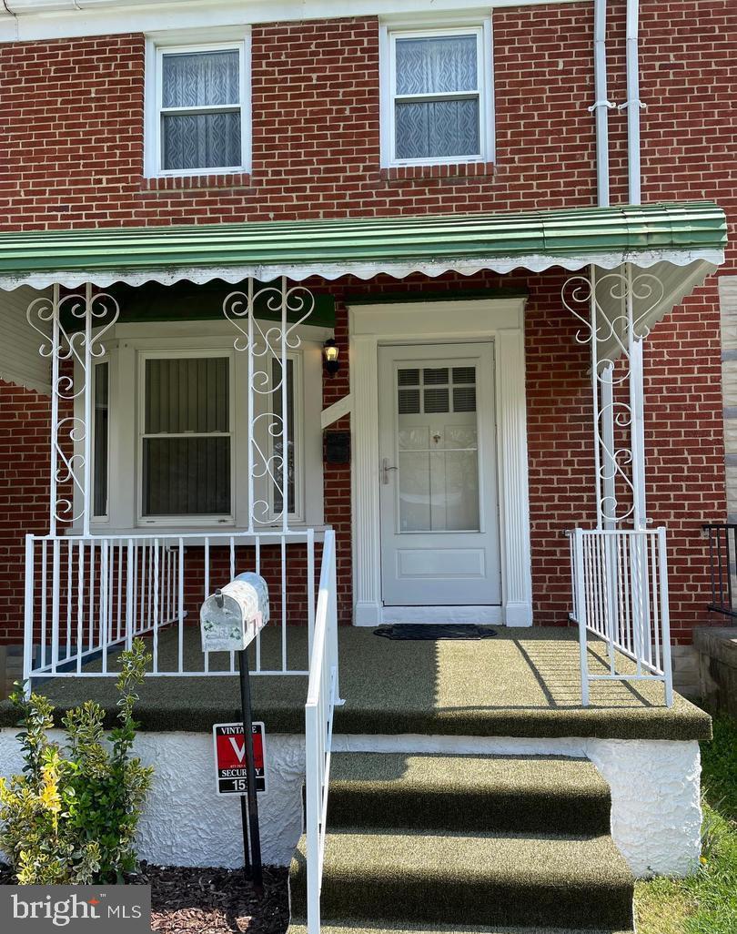 doorway to property featuring brick siding
