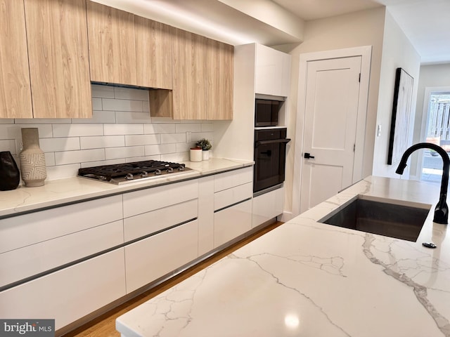 kitchen with stainless steel appliances, a sink, and modern cabinets