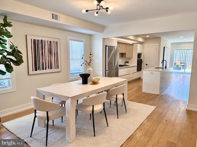 dining area with light wood finished floors, a chandelier, recessed lighting, baseboards, and visible vents