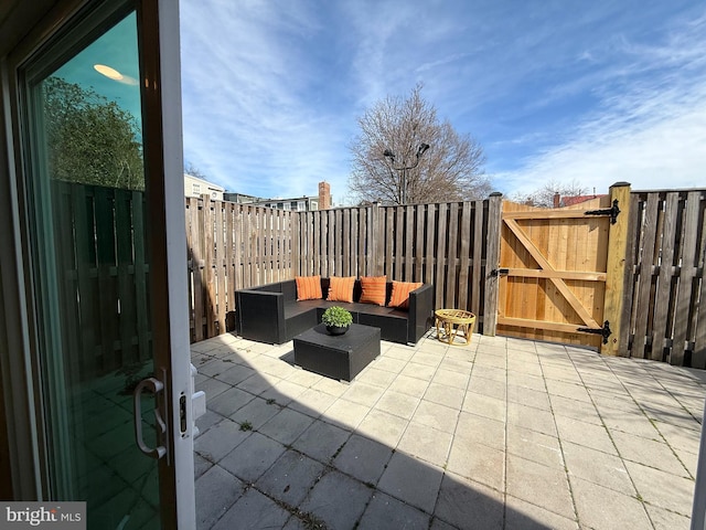 view of patio with an outdoor living space, a gate, and a fenced backyard