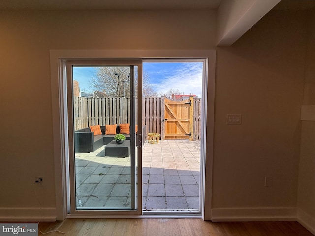 doorway featuring baseboards and wood finished floors