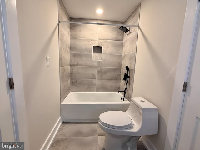 full bath with toilet, baseboards, and shower / tub combination