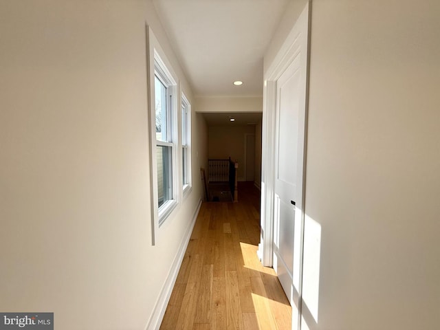 corridor featuring recessed lighting, baseboards, and light wood finished floors