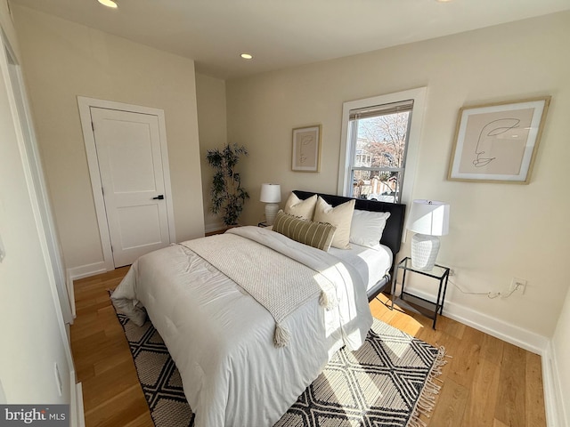 bedroom with recessed lighting, light wood-style flooring, and baseboards