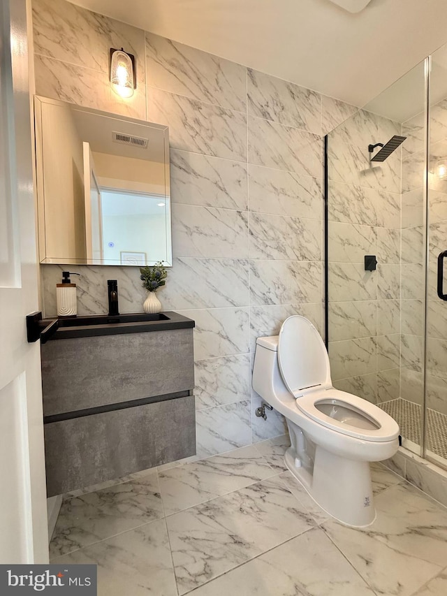 bathroom featuring visible vents, marble finish floor, toilet, tile walls, and a shower stall