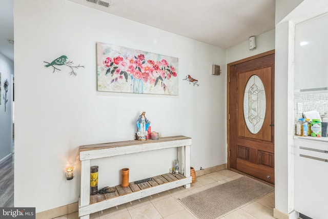 entryway with baseboards, visible vents, and tile patterned flooring