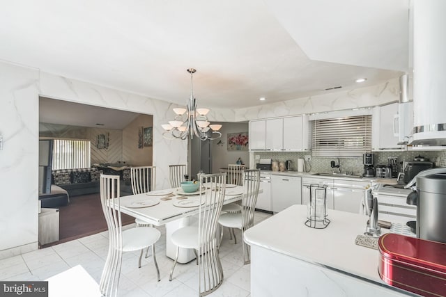 dining space featuring recessed lighting, an inviting chandelier, and marble finish floor
