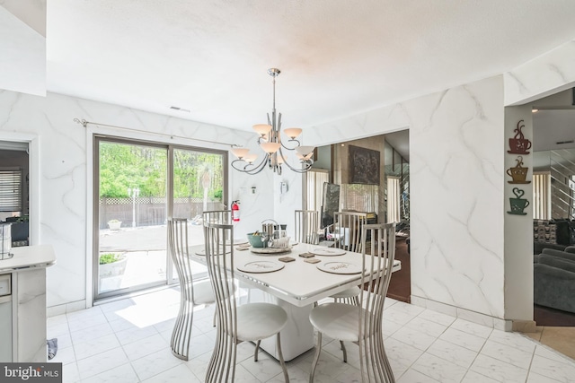 dining area with visible vents, a chandelier, and marble finish floor
