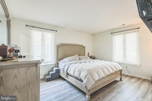 bedroom featuring light wood-style floors and baseboards
