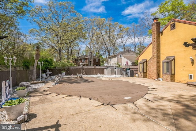 view of swimming pool with a patio and fence