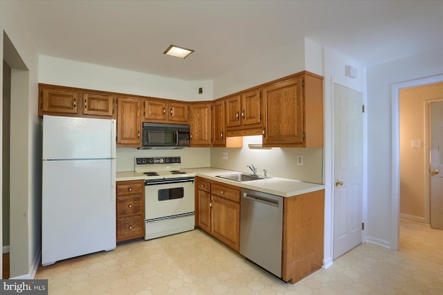 kitchen with a sink, light floors, white appliances, and light countertops