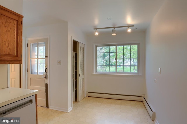 interior space featuring rail lighting, light floors, and baseboard heating